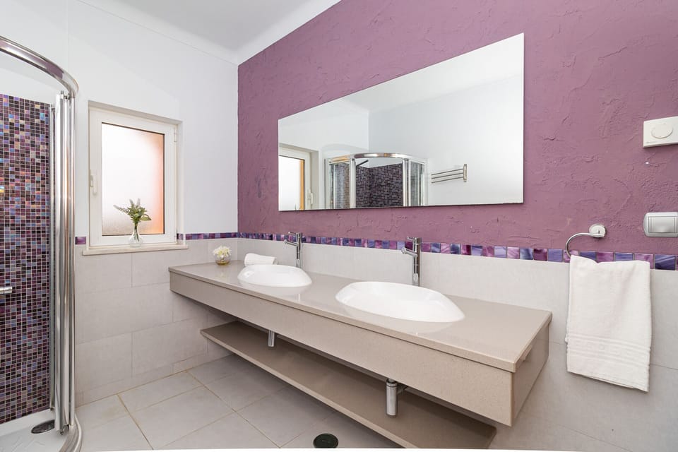 Modern bathroom with dual sinks and purple feature wall — Villa Farol, holiday villa in Vila do Bispo