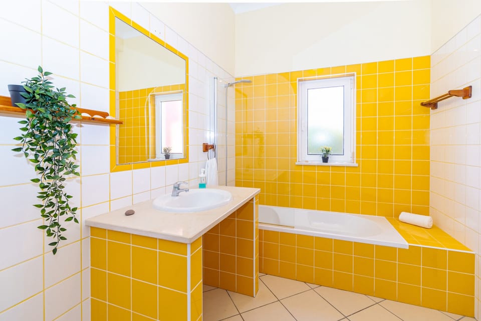 Modern bathroom with vibrant yellow tiles — Villa Farol, holiday villa in Vila do Bispo