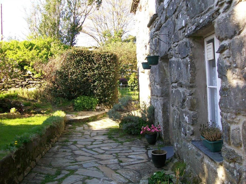 Front of House in sunshine with guests garden to the side