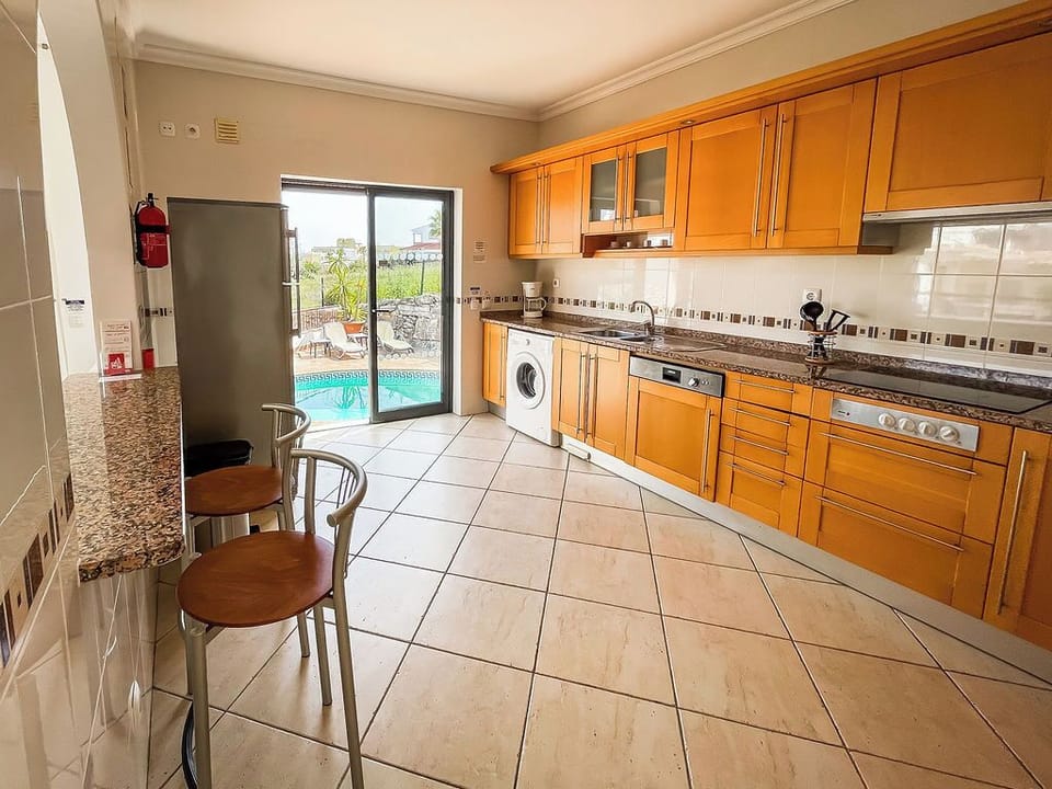 Kitchen with washing machine, dishwasher, hob, double oven, fridge freezer.
