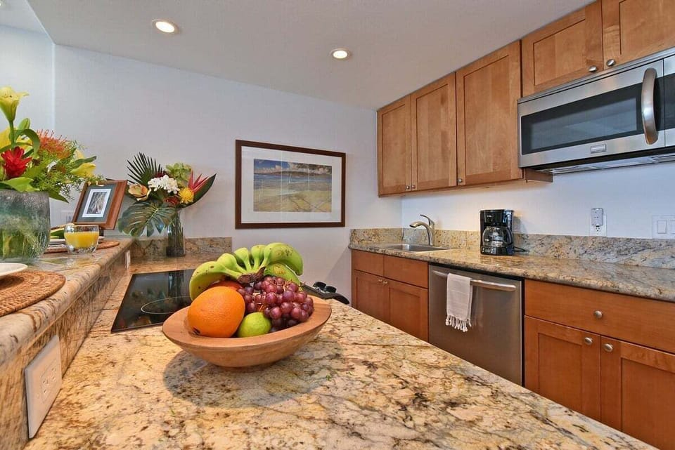 A stylish kitchen with granite countertops, stainless appliances, and warm natural lighting.