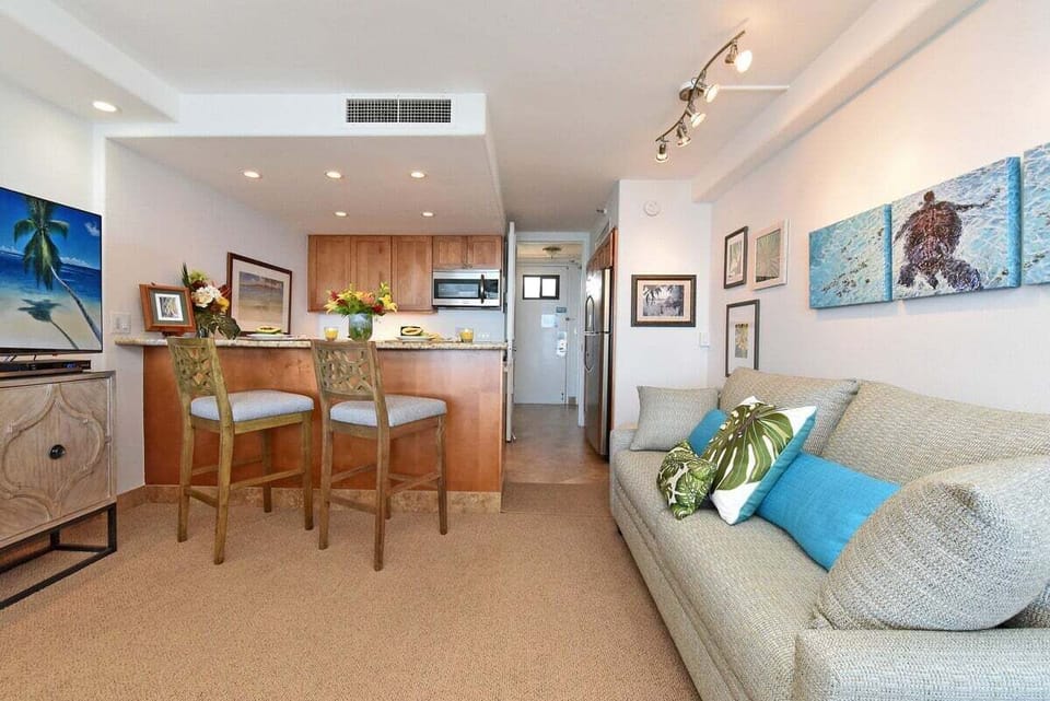 A welcoming dining and living area with tropical accents and seamless access to the lanai and ocean views.