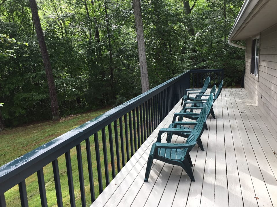 Large deck with comfortable chairs overlooking pond, and four burner Char-Grill.