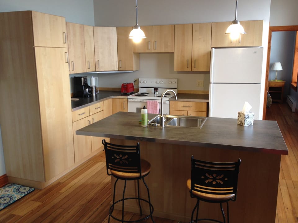 Full kitchen with a sit at island.