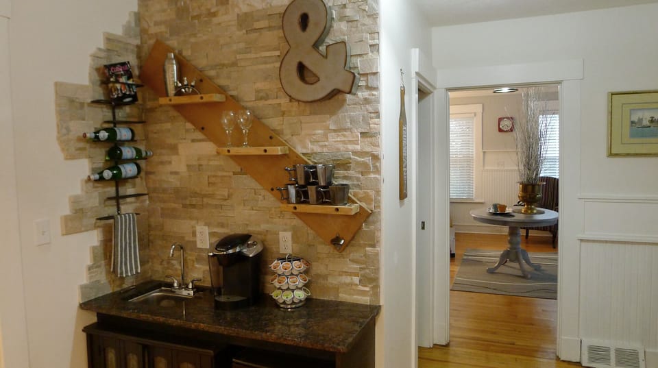 Beverage station has coffee supplies and small bar fridge.
