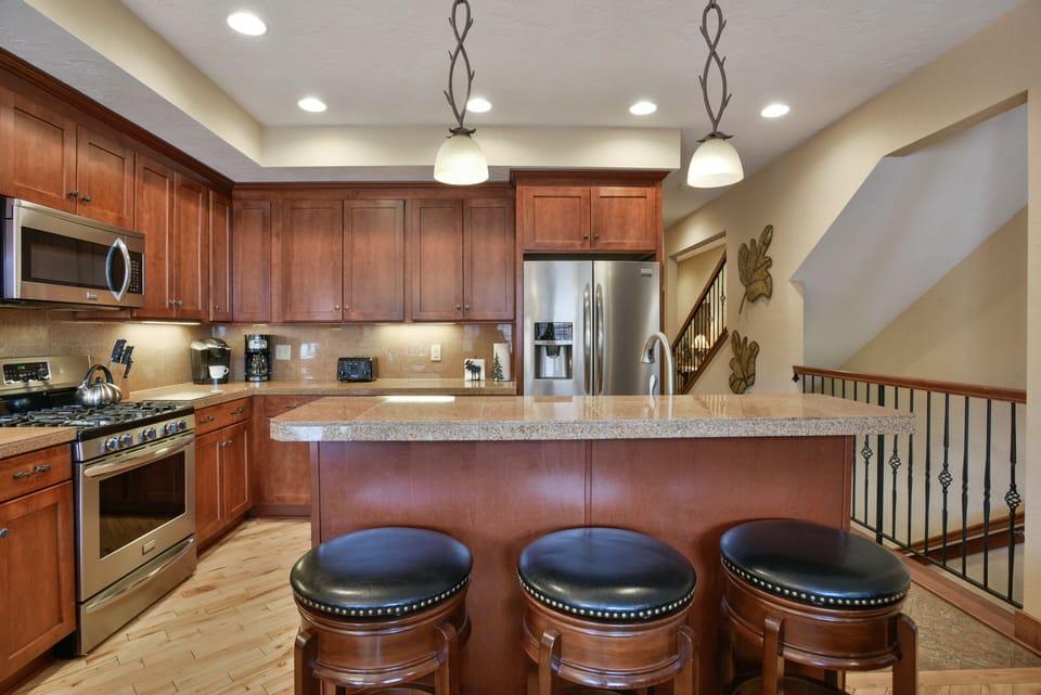 Gourmet kitchen with granite counters, hardwood floors and stainless appliances