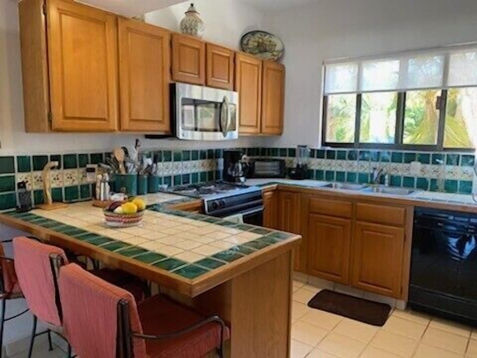 Kitchen with breakfast bar. Fully equipped w/ pots & pans, utensils, dishes, etc