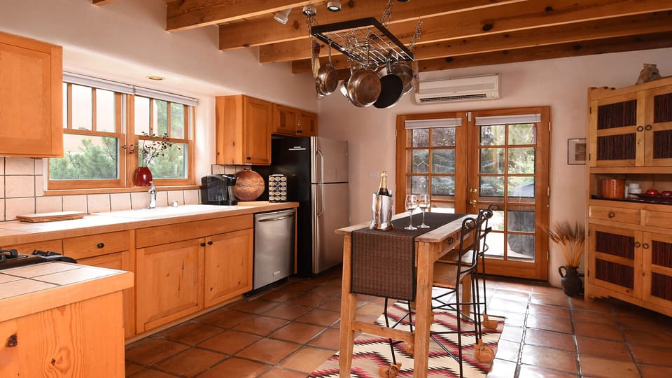 The sun-filled kitchen is fully equipped with pots, pans, utensils, & appliances
