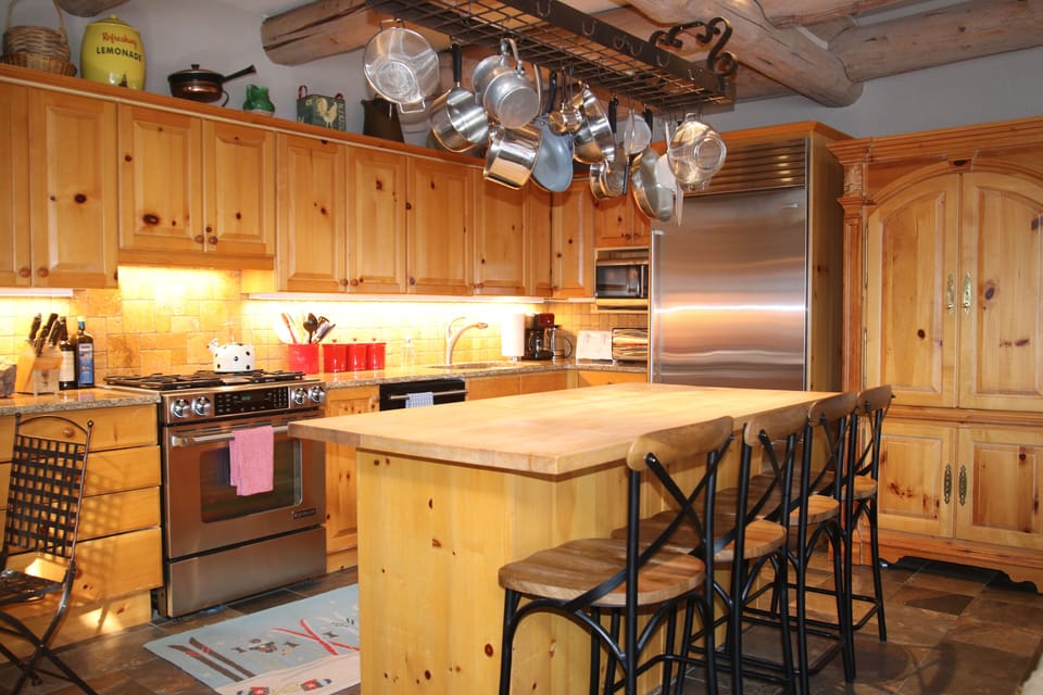 Fully stocked kitchen with gas range and large refrigerator. 