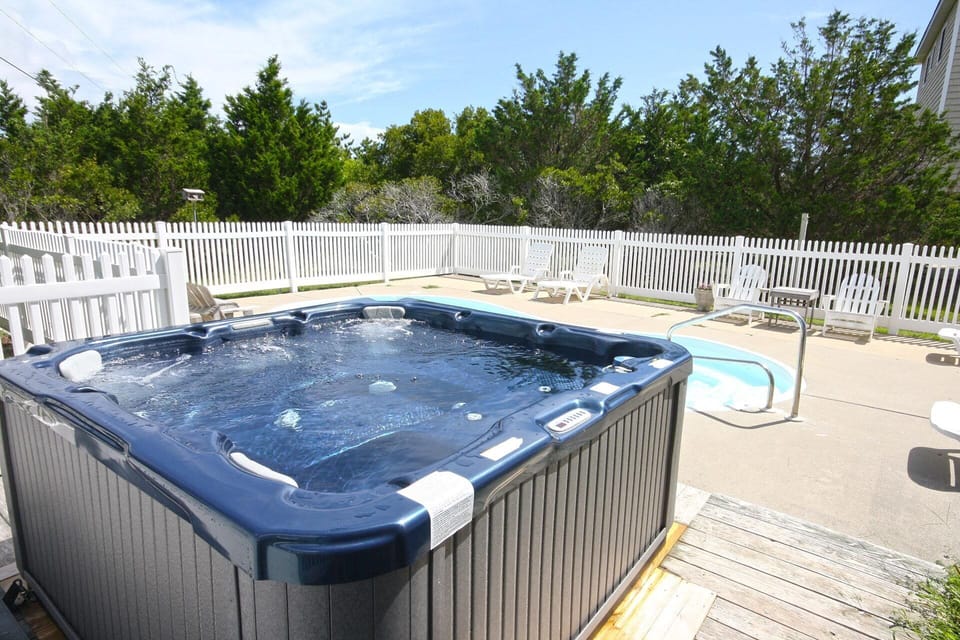 A spacious 6-person hot tub overlooks the pool area.