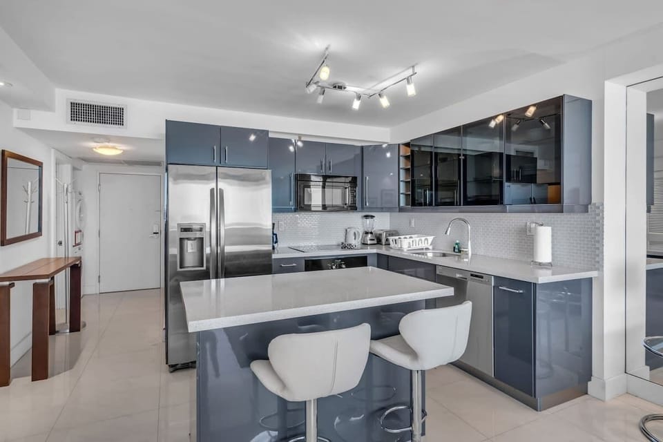 "Whip up meals in style—fully equipped kitchen with island seating, stainless appliances, and clean design!"