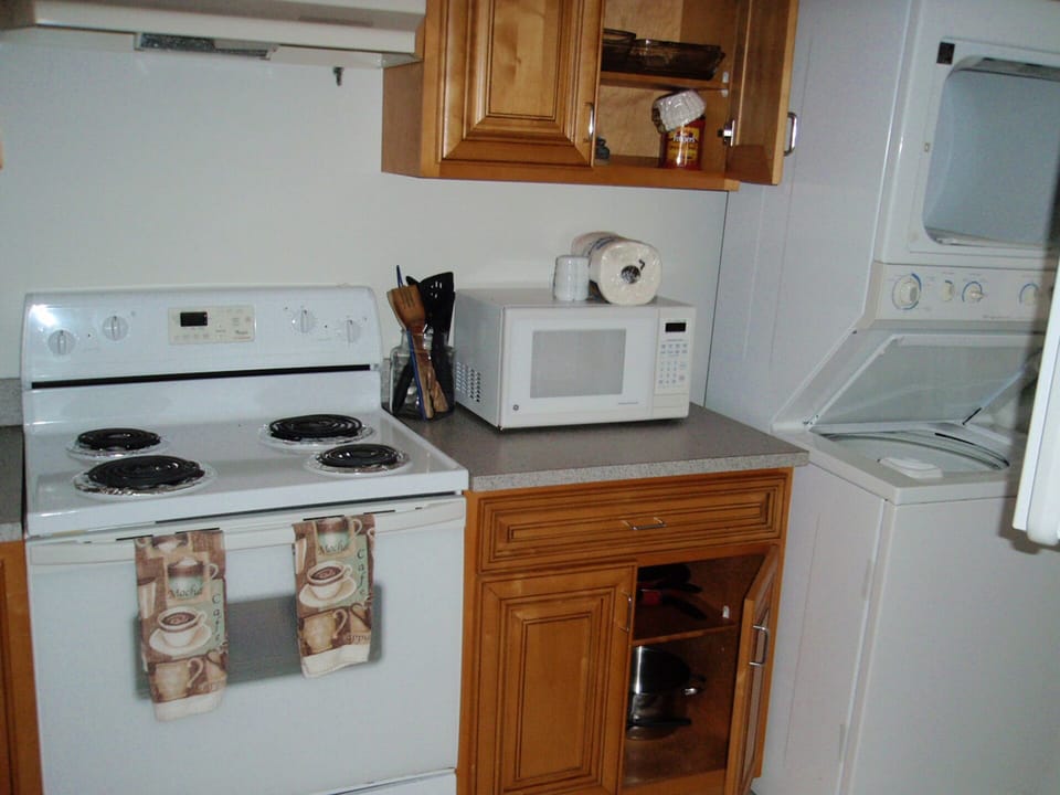 kitchen with sore microwave and full stack washer/dryer