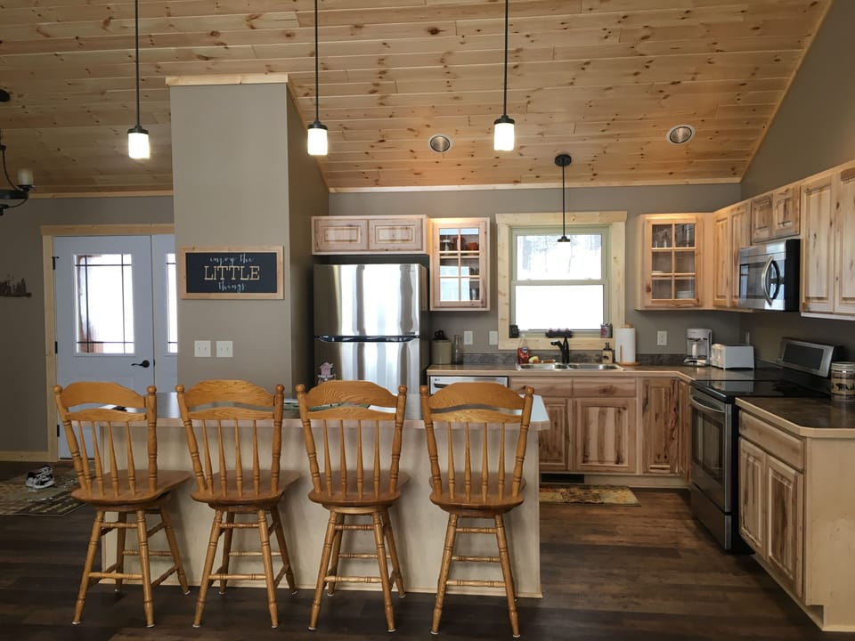 Modern kitchen with large island.  Dishwasher, refrigerator, microwave & stove. 