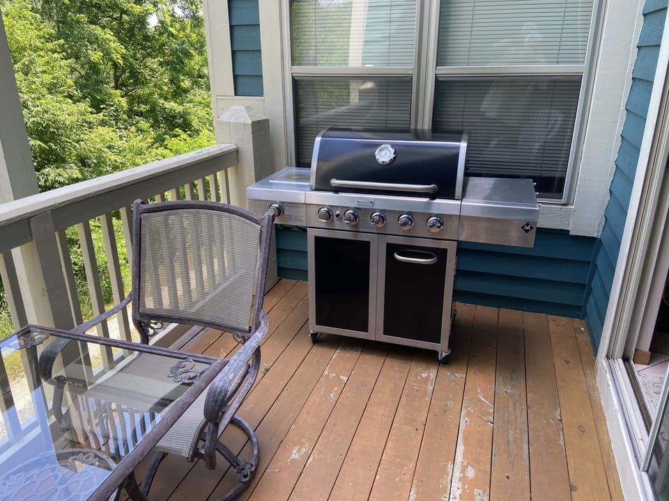 Small deck off kitchen with Gas Grill, table and chairs.