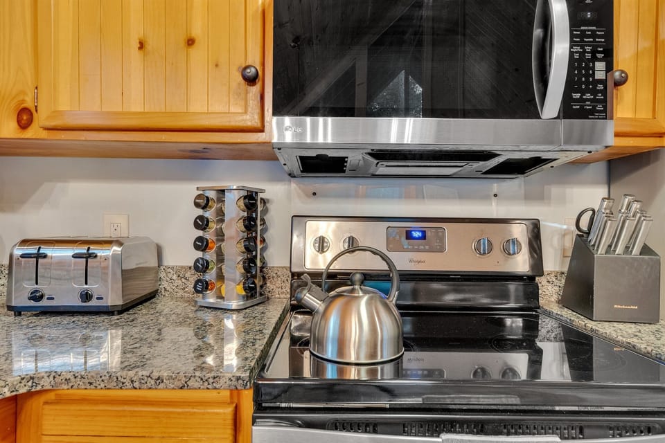 Fully stocked kitchen with toaster, kettle, and spice rack