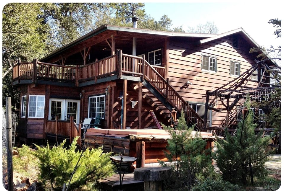 Back side of house with upper deck and jacuzzi.