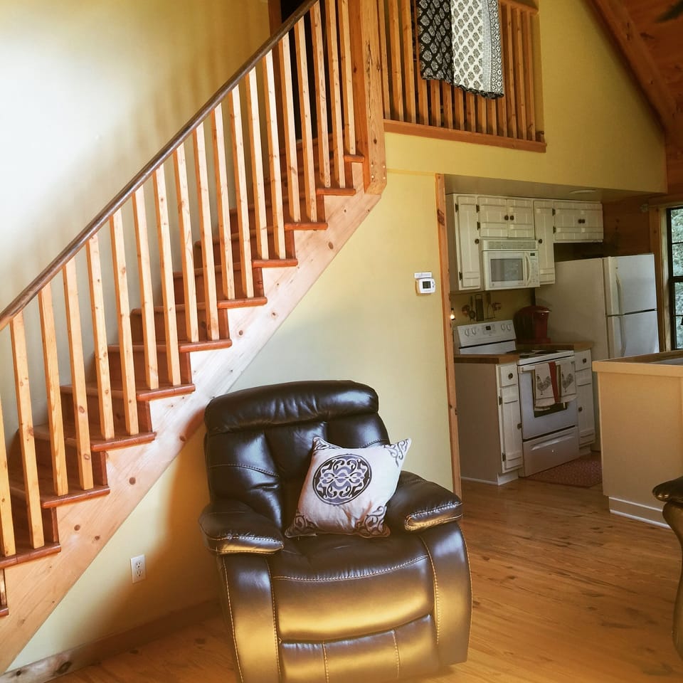 View from the fireplace looking upstairs to the master bedroom and to kitchen.