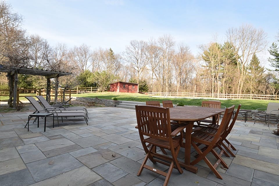 Stone patio with lounge furniture and umbrellas.  