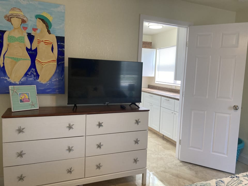 Master has six drawer dresser and TV.