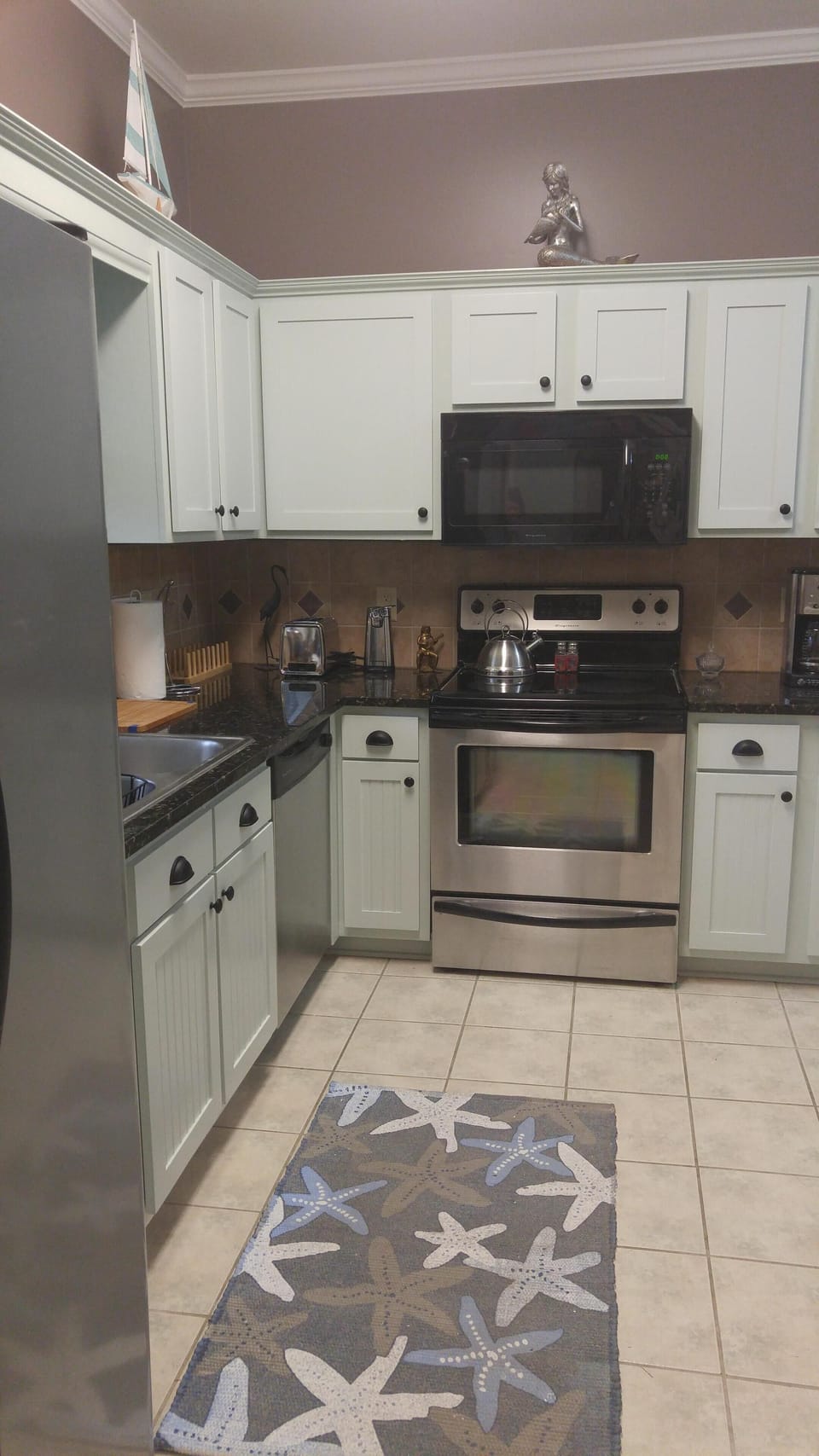 Kitchen has all stainless steel appliances and laundry area w/ washer and dryer