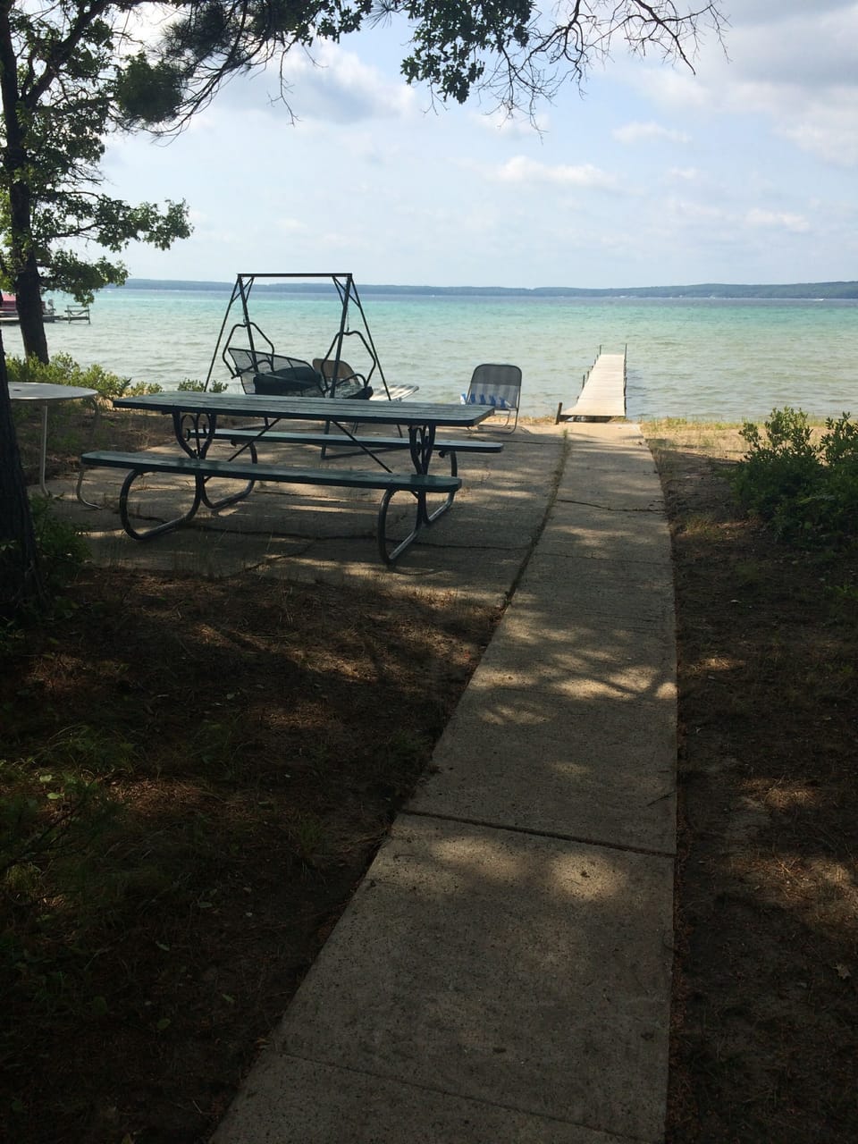 Walkway from cottage to patio with swing, picnic  and dock just beyond!