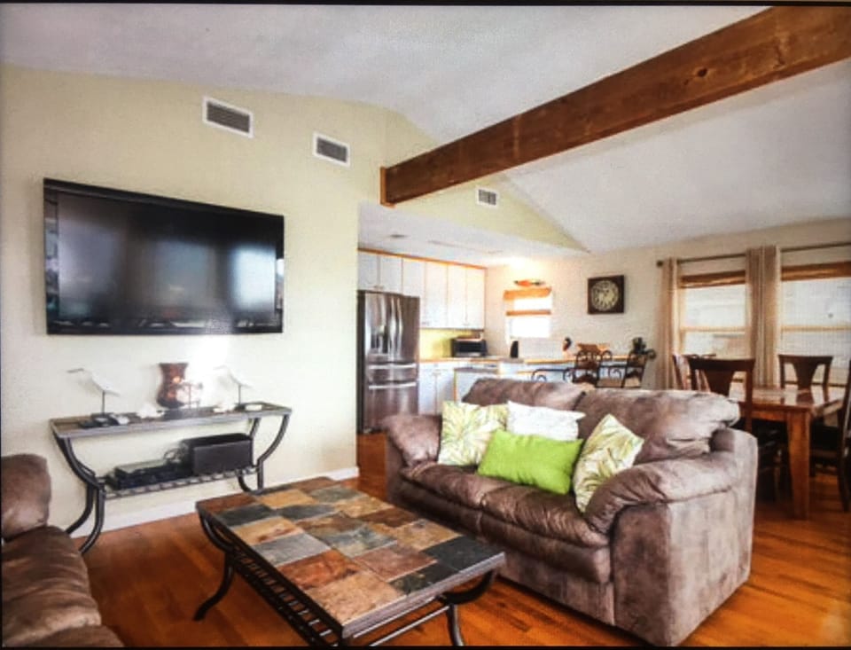Flat screen TV in living area.  Open concept kitchen and dining.