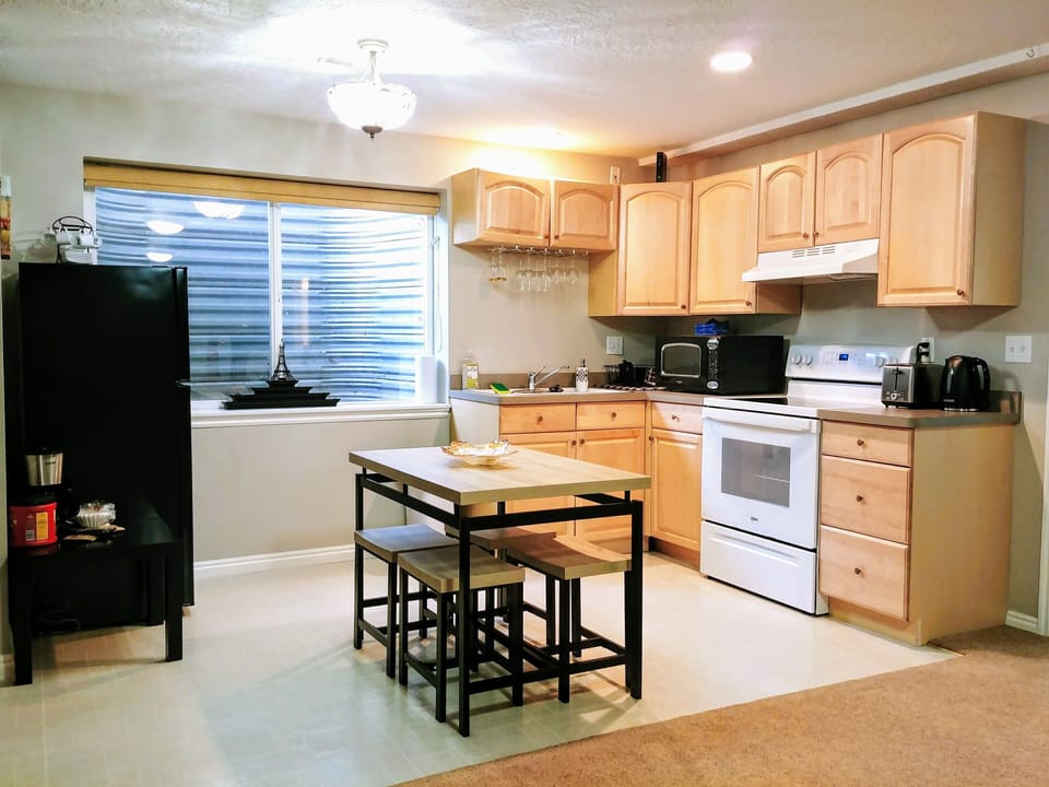 Kitchen with microwave, brand new stove, oven, fridge, kettle, toaster, pots ...