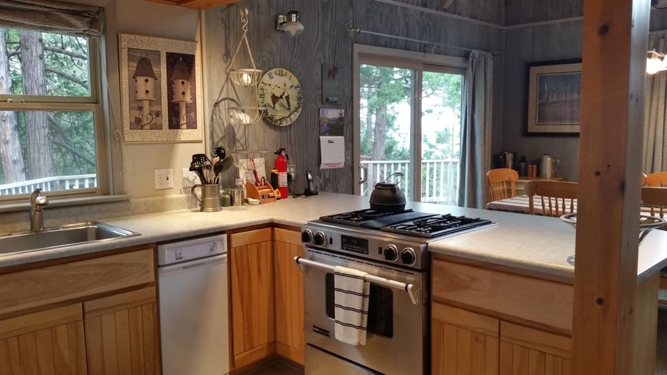 Modern kitchen adjacent to a voluminous great room - stovetop, oven, & compactor