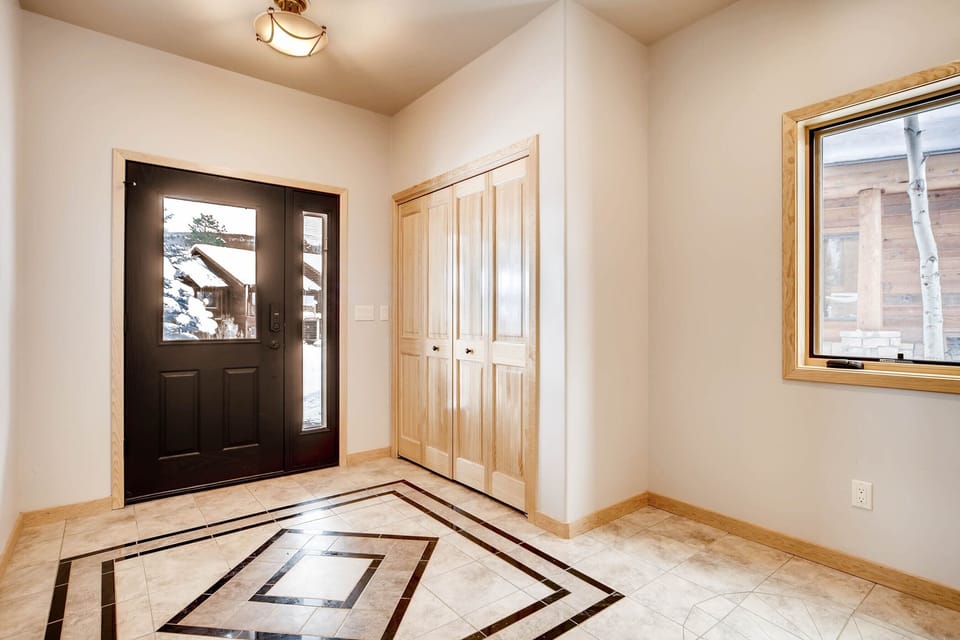 Tiled Foyer with storage for coats and boots, plus a drain in the floor!