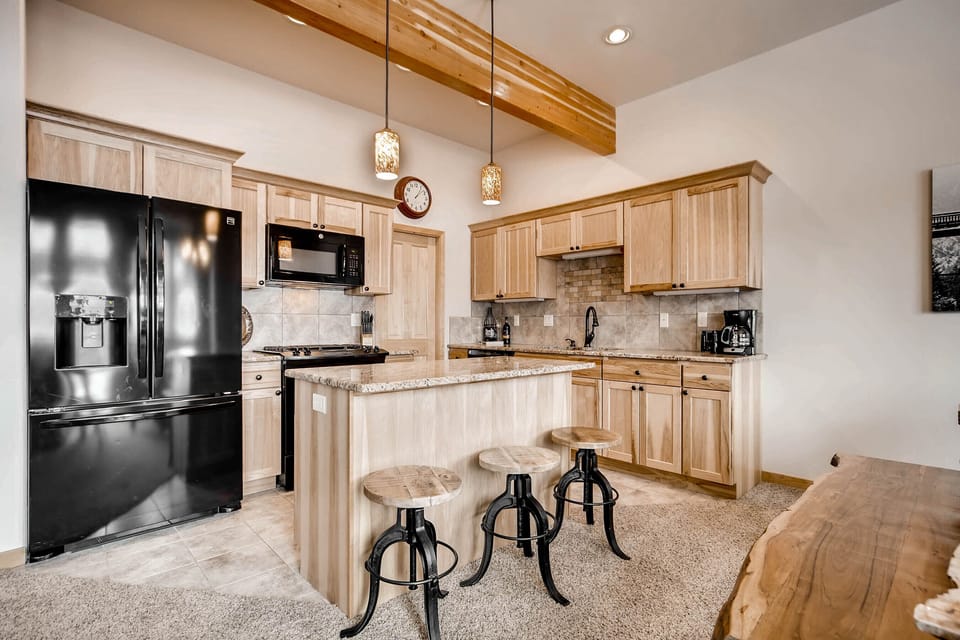 Kitchen with stools for additional seating, new appliances, and a large pantry
