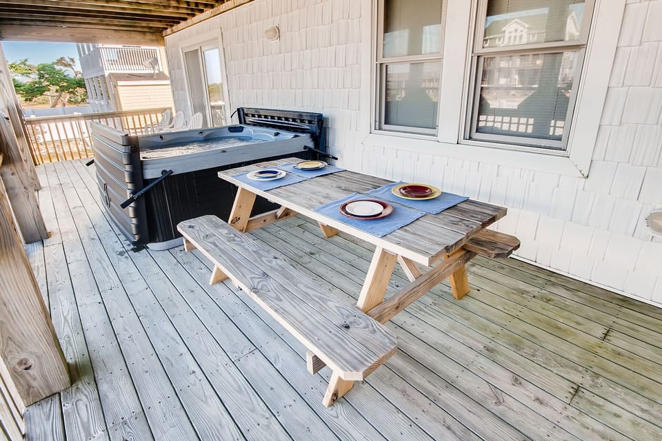The picnic table located adjacent to the 6-person hot tub offers space to lounge at.