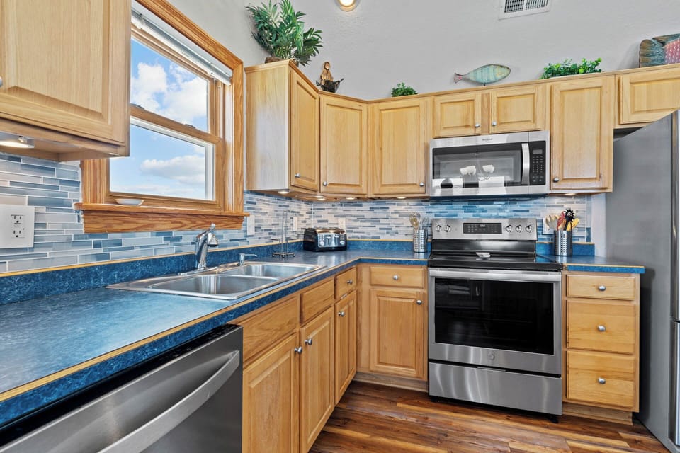 The kitchen is complete with stainless steel appliances and beautiful glass backsplash.