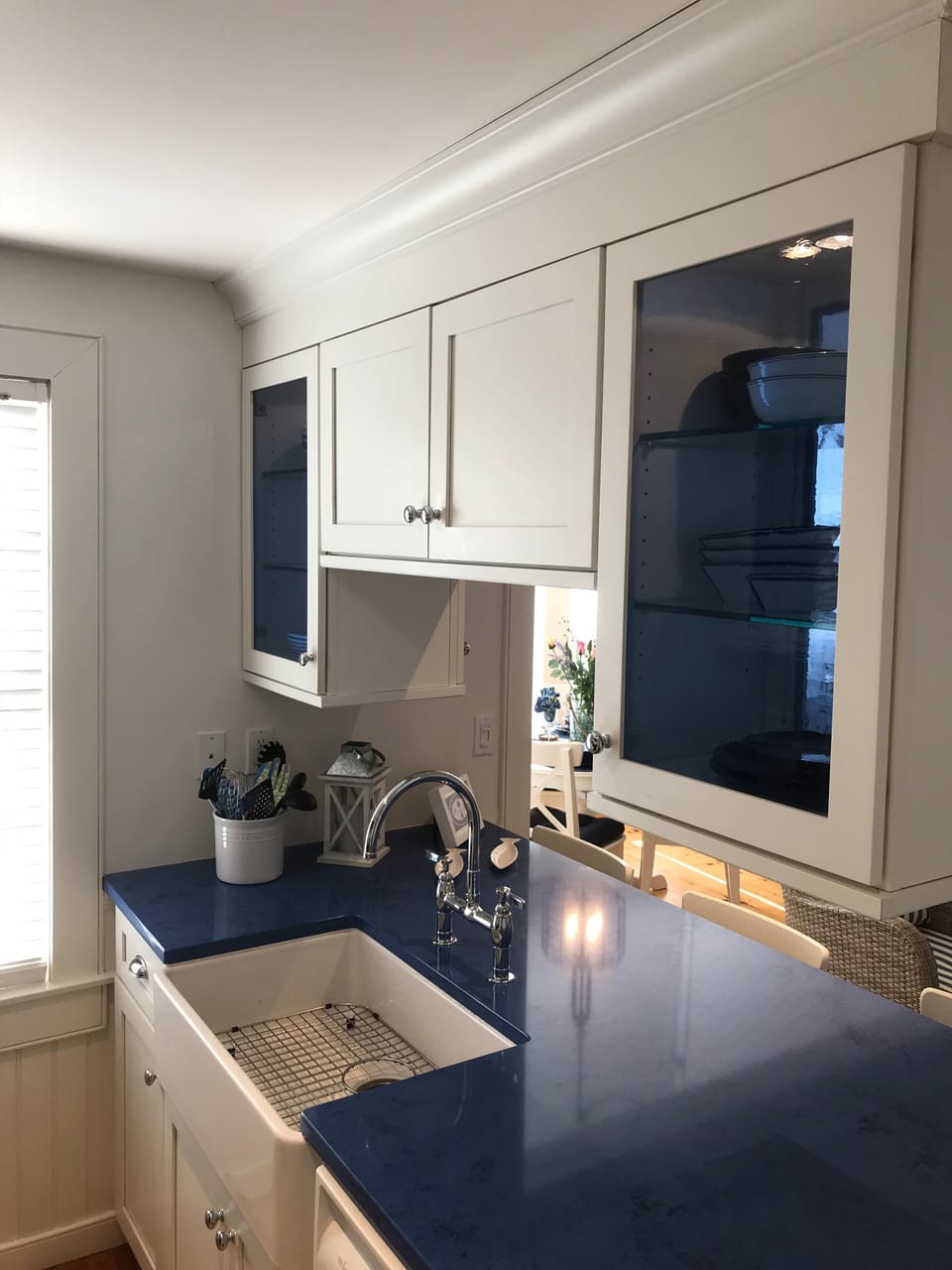 Blue glass cabinets house new beach themed dinnerware with cottage style sink.