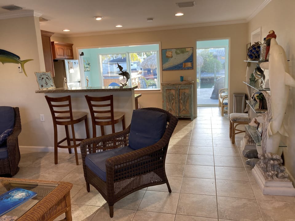 Living area with breakfast bar is open to kitchen and beyond to canal back yard
