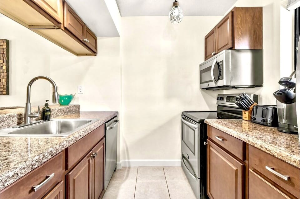 Kitchen w/ a dishwasher, electric stove, microwave, refrigerator, and a freezer.