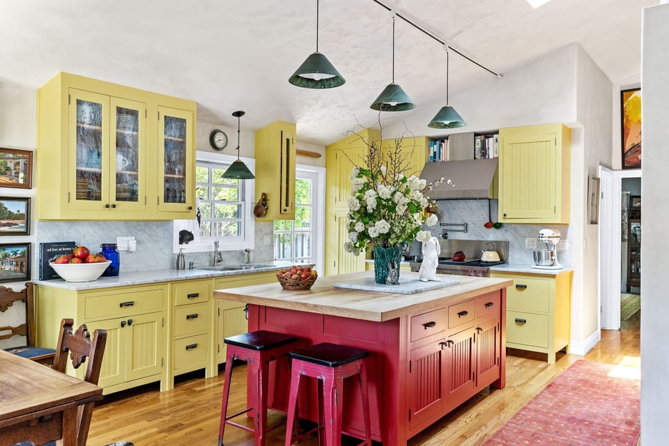 Bright and cheerful kitchen featuring sunny yellow cabinets and red island
