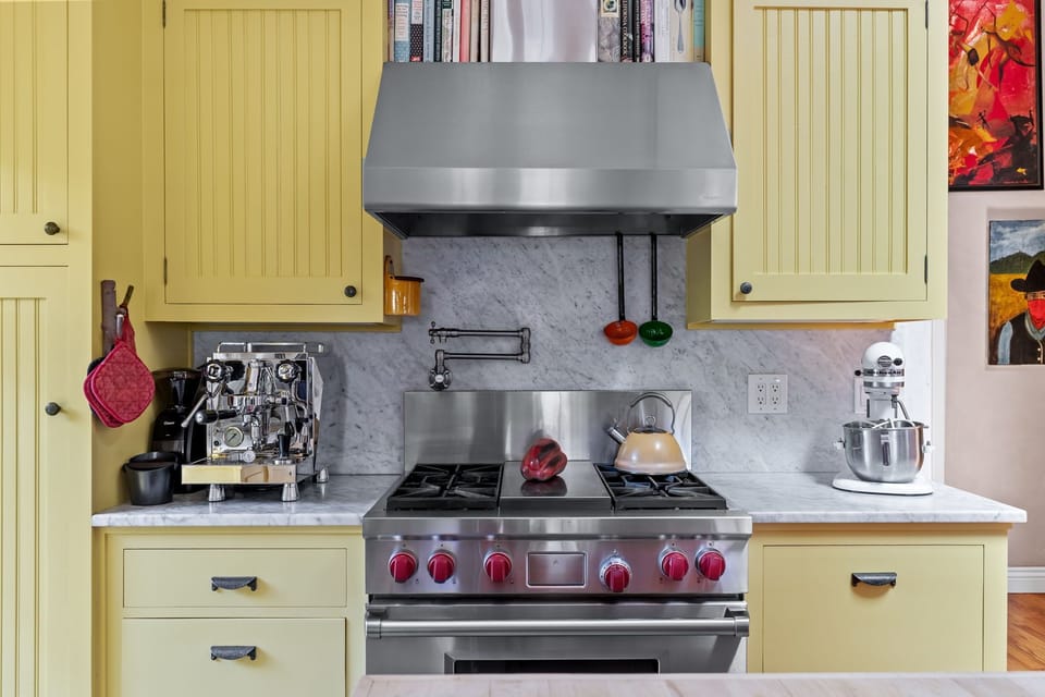 Gourmet kitchen with professional-grade appliances and sunny yellow cabinetry