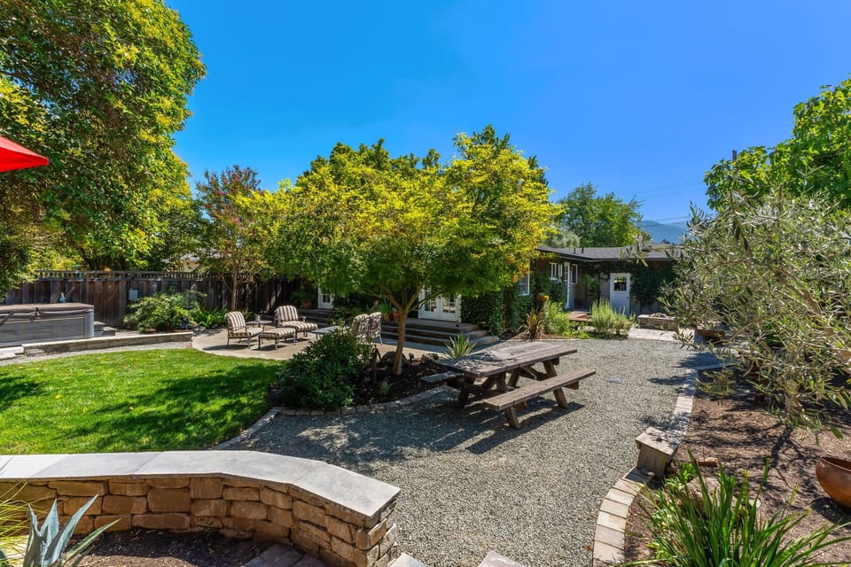 Spacious backyard retreat with multiple seating areas and lush landscaping