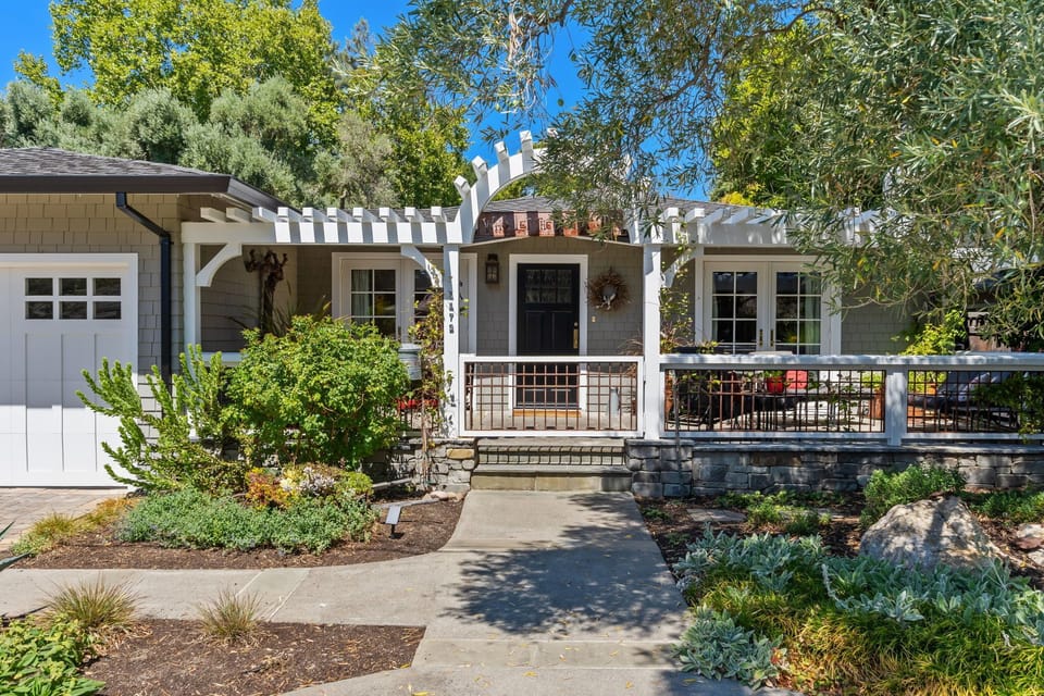 Charming craftsman bungalow with inviting front porch and lush landscaping.