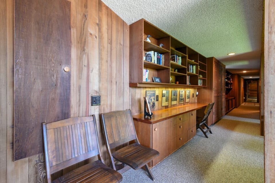 Main hall downstairs, framed articles along the wall showcase the homes` unique architecture and history