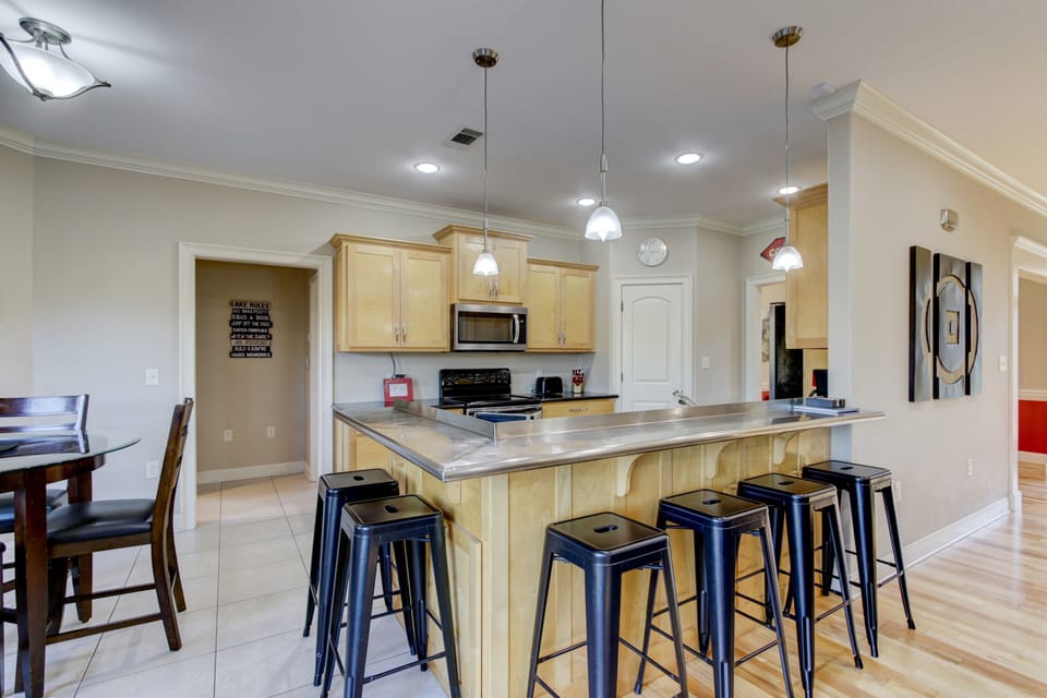 Kitchen bar. Hallway leads to primary and laundry rooms.