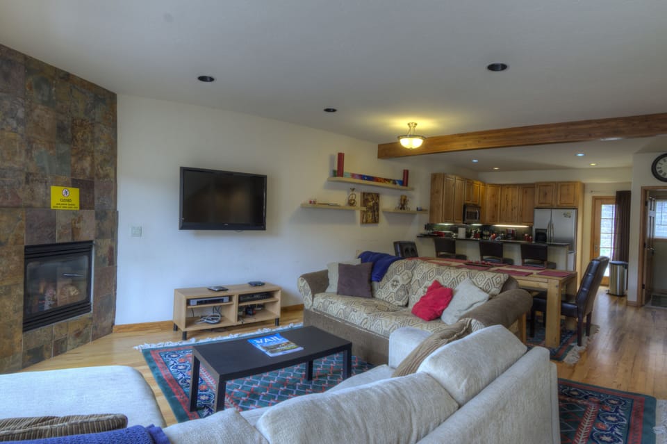 Middle floor contains kitchen, dining table, and living room.