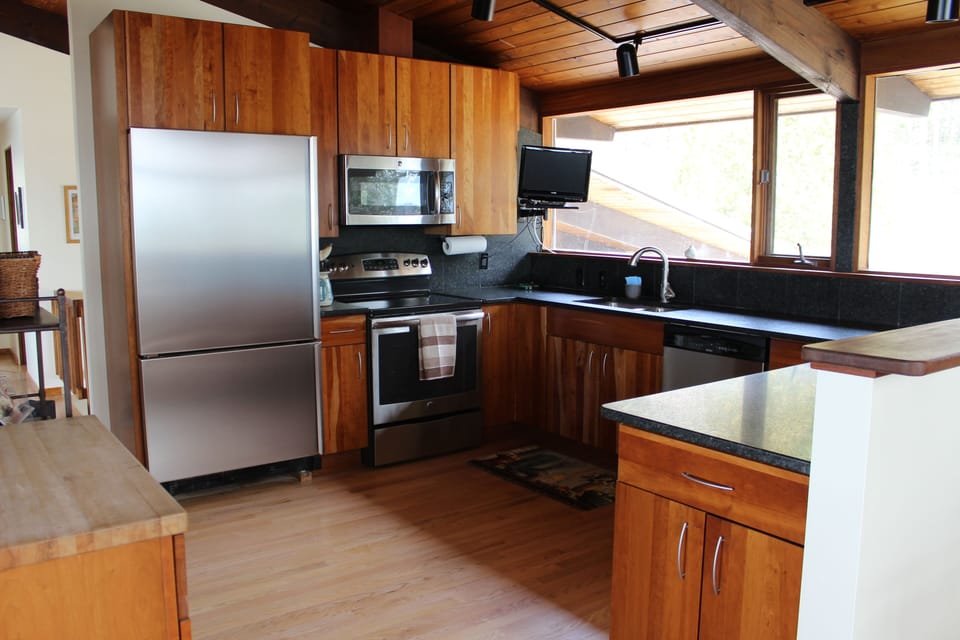 Kitchen with stainless steel and cherry wood cabinets.