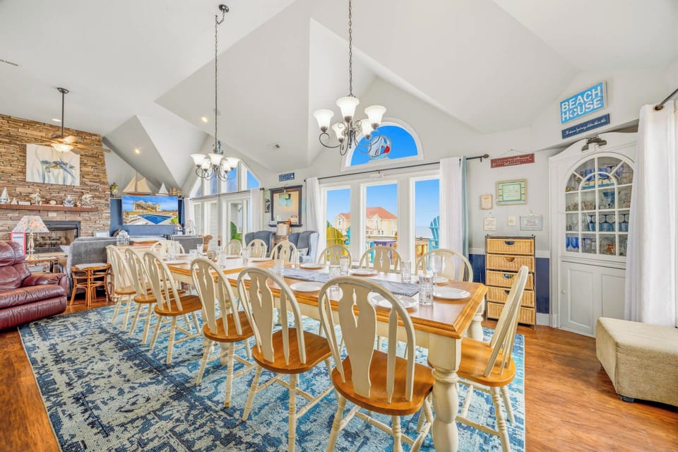 Gather around this spacious dining table where your group can enjoy meals together under soaring vaulted ceilings. Coastal charm meets comfort in this bright, open space with warm wood floors and beachy décor throughout.