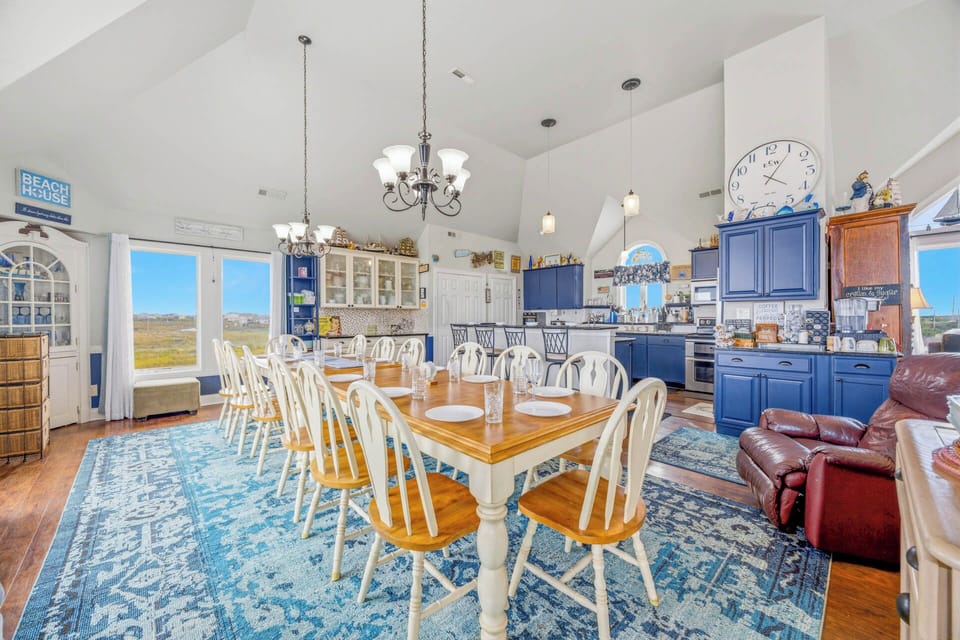 Gather around this spacious dining table with plenty of room for your whole group, then step into the fully equipped kitchen to prepare your favorite meals. Natural marshland views frame this inviting open-concept space.