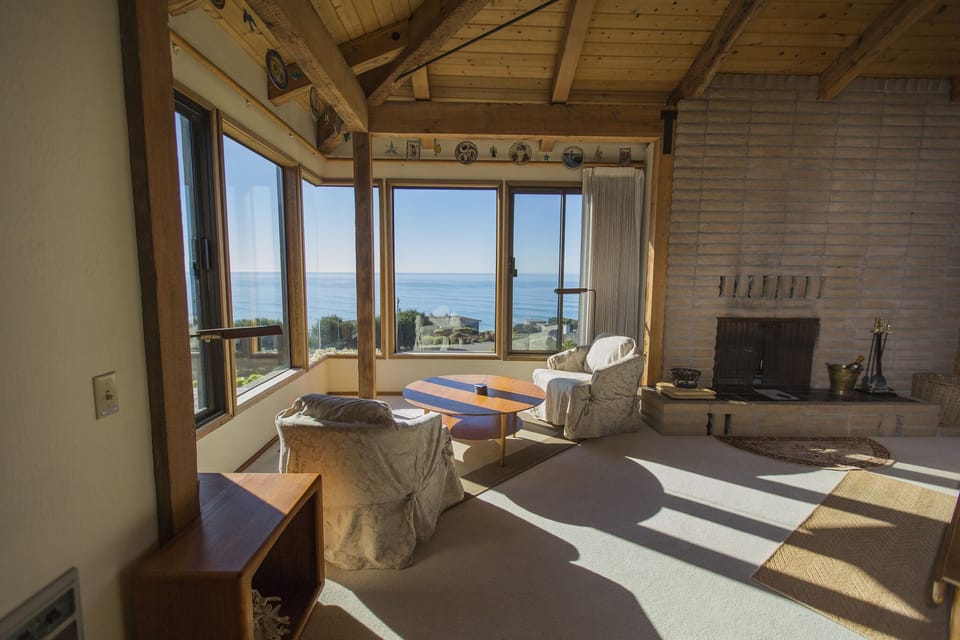 Cozy corner overlooking ocean in living room with fireplace