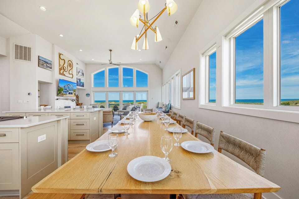 Gather around this stunning dining table with sweeping ocean views through expansive windows. The open layout flows seamlessly from kitchen to dining to living space, creating an ideal setting for your group meals and memorable conversations.