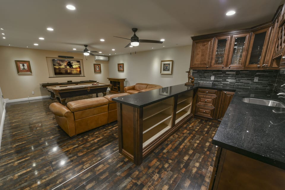 Game room- open bar, reclining leather sofa,  75" TV, billiards, shuffle board