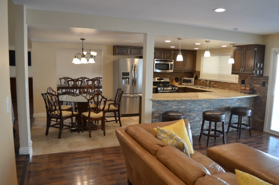 Large open area showing granite kitchen island and bar counter, nook and den 
