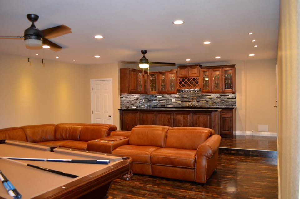Game room showing open bar, pool table and top grain reclining leather sectional